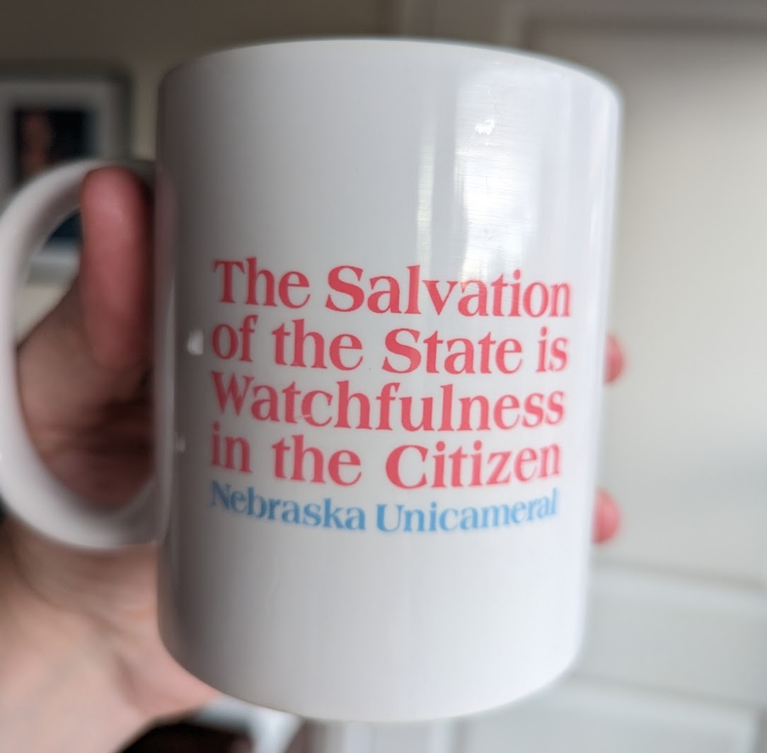 A coffee mug which reads: The Salvation of the State is Watchfulness in the Citizen